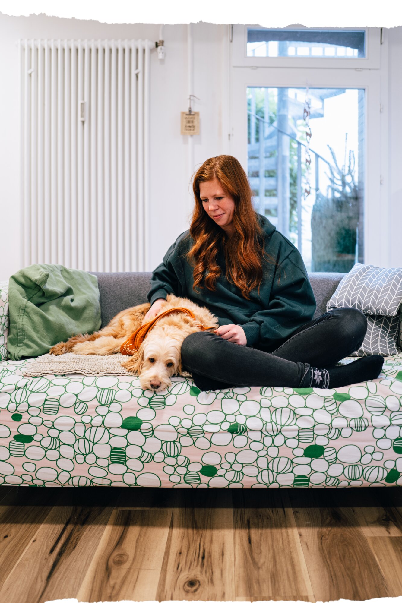 Mädchen mit Hund auf dem Sofa in der Wohngruppe Saturn